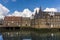 With a backdrop of Cumulus clouds, birds circle above eighteen-century mills in the Three Mills complex in Lee Valley, London