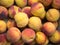 Backdrop of stacked yellow red peaches