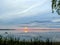 Background with abstract vivid purple pink sunset sun and cloudy sky reflecting in Razna lake water, Latvia