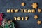 Background with baked gingerbread words new year 2017 and star-shaped biscuits with decorated fir branch. creative idea
