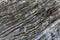 Background on the basis of the texture of rock. Gray-brown stone texture with inclined weathered stripes