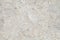 Background is beige marble slab with furrows from cuts, uniform texture