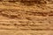 Background of beige sand of sandy cliffs. Close up of the texture of the big sandy cliff