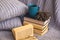 Background of blue hand-knit plaid and pillows in cosy home with dried bouquet of lavender flowers, books, mug of coffee, garland.