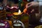 Background blurred woman\'s hand lights a candle in a candlestick with a match