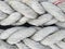 Background of braided old thick ropes. Sturdy fishing ropes to tie up the boat. Close up. Detail of a used Trawler white fishing