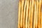 Background of breadsticks stacked in rows and sackcloth. Top view on breadsticks. Copycpase