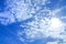 Background of bright sky blue colored sky with white cloud and sunshine
