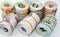 Background of bundles and rolls of Egyptian money currency cash banknotes rolled up with rubber bands in different bill values of