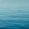 Background of calm blue water with small waves and endless ripples