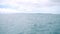 background of the calm sea with island at far away. view from ferry boat moving with water splash passing..