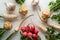 Background of celery roots, parsley, radishes with leaves and garlic on white table