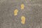 Background of cement walkway with three yellow footprints