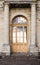 Background of city buildings from limestone. Vintage arched door. The old town of Gatchina. Russia.