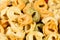 Background of colored tortellini, ring-shaped pasta