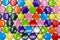 Background of colorful, lined crown corks or caps in different colors such as red, yellow, blue, orange and gold