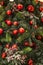 Background with cones and red balls, with red berries on a twig, glowing garlands on pine branches