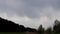 Background of dark clouds before a thunderstorm over spring fields and forest