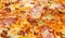 Background of delicious classic italian pizza with ham, sausages, corn, cucumbers and cheese
