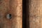 Background and detail of a rusty sheet piling that has a hole cut in it on the left side