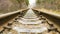 Background of diagonal railroad at dusk with copy space. Rails, sleepers, fastenings and crushed stone close up. Railway