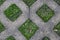 Background of diamond shaped concrete pavement with grass growing in the openings on a very wet day - interesting and colorful