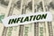 On the background of dollars lies a piece of paper with the text - INFLATION