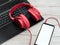 Background earphones musical red overhead on the pc keyboard. Audio music headphones with laptop and with smartphone with white