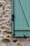 Background facade with wood window painted in green.