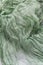 Background folds of sparse margilan green color hand-colored silk