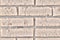 Background in the form of brickwork with round dents. The texture of the old brick blocks with cement joints. Damaged dirty brick