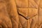 Background in the form of a fragment of the back of a winter jacket made of genuine brown soft  leather