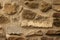 Background in the form of a fragment of a stone wall with stones of light and brown rubble