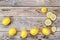 Background with fresh lemons and lemon slices on grunge wooden b