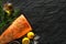 Background with fresh salmon fillet and the ingredients needed to prepare it on a black background