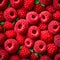 Background of fresh sweet red raspberries arranged together representing concept of healthy diet