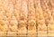 Background full of tiny wooden sculptures depicting buddhist monks meditating with toothpicks.
