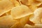 Background golden potato chips texture. Crispy unhealthy snack isolated