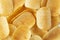 Background golden potato chips texture. Crispy unhealthy snack isolated