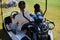 Background of golf bag in back of cart in sports club with couple driving