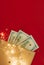 Background for holiday card with money US dollars. Background of one hundred dollar bills. Banknotes, paper currency on red