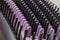 Background image of black and purple bristles of an electric heat brush for straightening hair