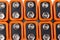 Background image of a large number of orange batteries, standing in several rows