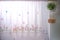 Background of kitchen windows dressed with lace curtain and flower pot