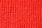 Background of knitted woolen fabric of red color. the binding texture of the elastic band is one front one wrong