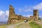 Background landscape view tourists walk in a Sudak fortress amidst the ruins of ancient towers in the Crimea