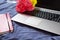 Background of laptop, notebook, flowers close up on bed