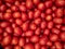 A background of a large number of small red tomatoes. Background from vegetables on a shop window.