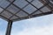 Background of large urban shade structure, blue sky and clouds copy space