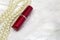 Background. Lipstick, necklace on white fur rug. Slight background blur